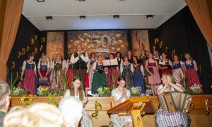 Mitwirkende stehen beim Jubiläumskonzert der Singgemeinschaft Döbriach gemeinsam vor der Bühne.