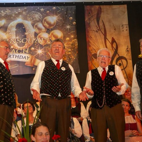 Vier Sänger in Tracht singen gemeinsam auf der Bühne des Jubiläumskonzerts.