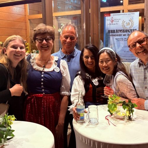 Eine Gruppe von Gästen sitzt nach dem Jubiläumskonzert gemeinsam an einem Tisch.